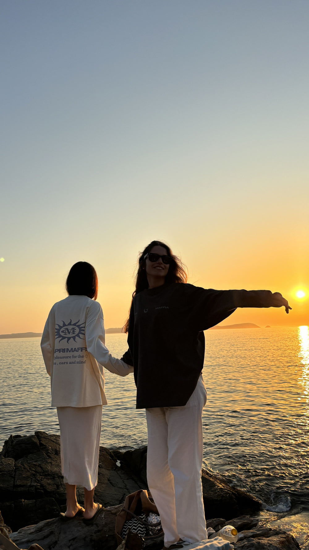 Dos personas frente al mar al atardecer
